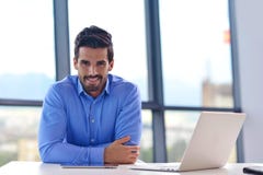 Jeune homme heureux d'affaires au bureau photo libre de droits Jeune homme heureux d'affaires au bureau photo libre de droits