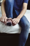 Jeune homme mettant dessus ou enlevant ses chaussettes Image stock Jeune homme mettant dessus ou enlevant ses chaussettes Image stock