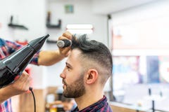 Jeune homme obtenant une coiffure dans un raseur-coiffeur photo libre de droits Jeune homme obtenant une coiffure dans un raseur-coiffeur photo libre de droits
