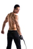 Jeune homme sans chemise musculaire avec le fouet et le gant clouté photographie stock Jeune homme sans chemise musculaire avec le fouet et le gant clouté photographie stock