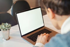 Jeune homme travaillant devant l'ordinateur portable avec l'écran blanc vide image libre de droits Jeune homme travaillant devant l'ordinateur portable avec l'écran blanc vide image libre de droits