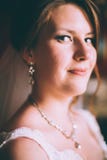 Jeune mariée magnifique dans la robe de mariage dans l'intérieur de luxe avec les bijoux de diamant posant à la maison et le mari Photo stock Jeune mariée magnifique dans la robe de mariage dans l'intérieur de luxe avec les bijoux de diamant posant à la maison et le mari Photo stock
