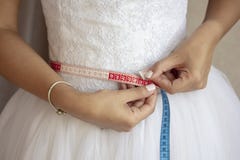 Jeune mariée mesurant sa taille avant le jour du mariage photographie stock Jeune mariée mesurant sa taille avant le jour du mariage photographie stock