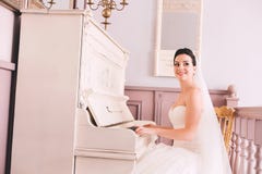 Jeune mariée mignonne jouant le piano image libre de droits Jeune mariée mignonne jouant le piano image libre de droits
