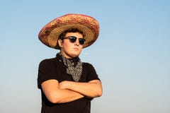Jeune personne masculine dans le sombrero et des lunettes de soleil dans le backgr clair de ciel photographie stock Jeune personne masculine dans le sombrero et des lunettes de soleil dans le backgr clair de ciel photographie stock