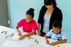 Jeune professeur donnant ? enfants d'Afro-am?ricain une le?on d'art et enseignant comment dessiner photographie stock Jeune professeur donnant ? enfants d'Afro-am?ricain une le?on d'art et enseignant comment dessiner photographie stock