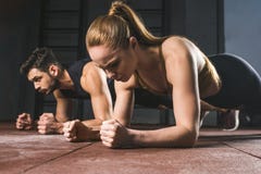 Jeune sportive et sportif faisant la planche image libre de droits Jeune sportive et sportif faisant la planche image libre de droits