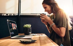 Jeune vlogger femelle observant son vlog sur l'ordinateur images stock Jeune vlogger femelle observant son vlog sur l'ordinateur images stock