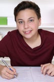 Jeune écriture d'étudiant dans son livre d'exercice à l'école photos libres de droits Jeune écriture d'étudiant dans son livre d'exercice à l'école photos libres de droits