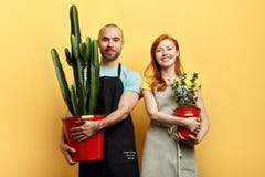 Jeunes ajouter gais heureux aux fleurs posant ? la cam?ra image stock Jeunes ajouter gais heureux aux fleurs posant ? la cam?ra image stock