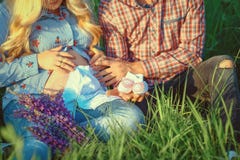 Jeunes ajouter à la femme enceinte regardant des vêtements d'enfants de présents et des personnes heureuses infantiles de chaussu photo libre de droits Jeunes ajouter à la femme enceinte regardant des vêtements d'enfants de présents et des personnes heureuses infantiles de chaussu photo libre de droits