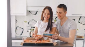 Jeunes boîte d'ouverture de couples et pizza heureuses de mise au plat banque de vidéos Jeunes boîte d'ouverture de couples et pizza heureuses de mise au plat banque de vidéos