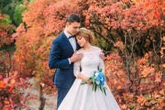 Jeunes couples attrayants stupéfiants dans le jour du mariage jeune mariée dans la longue robe blanche élégante et le bouquet ble photographie stock libre de droits Jeunes couples attrayants stupéfiants dans le jour du mariage jeune mariée dans la longue robe blanche élégante et le bouquet ble photographie stock libre de droits