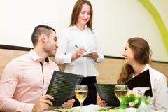 Jeunes couples au restaurant Image libre de droits Jeunes couples au restaurant Image libre de droits