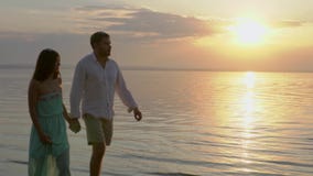 Jeunes couples heureux marchant près de la mer sur le coucher du soleil Concept de l'amour banque de vidéos Jeunes couples heureux marchant près de la mer sur le coucher du soleil Concept de l'amour banque de vidéos