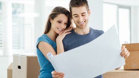 Jeunes couples prévoyant leur nouvelle maison image stock Jeunes couples prévoyant leur nouvelle maison image stock