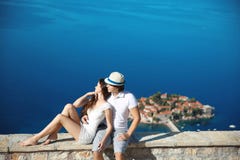 Jeunes couples romantiques dans l'amour au-dessus du bord de mer au-dessus de l'île de Sveti Stefan dans Budva, Monténégro Voyage Photographie stock Jeunes couples romantiques dans l'amour au-dessus du bord de mer au-dessus de l'île de Sveti Stefan dans Budva, Monténégro Voyage Photographie stock