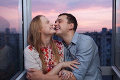 Jeunes couples sur le balcon embrassant et riant image stock Jeunes couples sur le balcon embrassant et riant image stock
