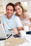 Jeunes couples utilisant par la carte de crédit sur l'Internet photographie stock Jeunes couples utilisant par la carte de crédit sur l'Internet photographie stock