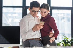 jeunes hommes d'affaires attirants dans l'habillement formel ayant le bureau roman et l'utilisation photographie stock jeunes hommes d'affaires attirants dans l'habillement formel ayant le bureau roman et l'utilisation photographie stock