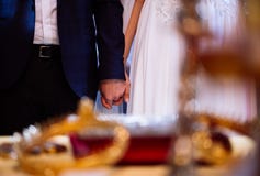 Jeunes mariés tenant des mains pendant la cérémonie d'église de mariage images stock Jeunes mariés tenant des mains pendant la cérémonie d'église de mariage images stock