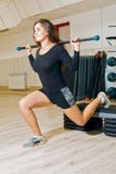 Jeunes trains sportifs de fille dans la chambre de forme physique la femme se tapit avec le bâton gymnastique sur la plate-forme photographie stock Jeunes trains sportifs de fille dans la chambre de forme physique la femme se tapit avec le bâton gymnastique sur la plate-forme photographie stock