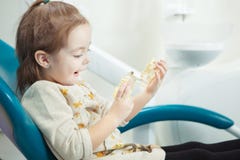 Jeux d'enfant avec la mâchoire humaine artificielle dans la chaise de dentiste photo libre de droits Jeux d'enfant avec la mâchoire humaine artificielle dans la chaise de dentiste photo libre de droits
