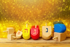 Jewish holiday Hanukkah background with spinning top dreidel on wooden table over golden bokeh stock images Jewish holiday Hanukkah background with spinning top dreidel on wooden table over golden bokeh stock images