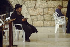 Jewish man sitting on a chair and holding bible book, praying at the sacred Wailing Wall, Western Wall, Jerusalem royalty free stock images Jewish man sitting on a chair and holding bible book, praying at the sacred Wailing Wall, Western Wall, Jerusalem royalty free stock images