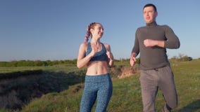 Jog outdoors, happy young athletic couple enjoying jog in nature and cuddling in sunny daylight after cardio workout stock footage Jog outdoors, happy young athletic couple enjoying jog in nature and cuddling in sunny daylight after cardio workout stock footage
