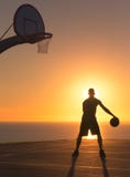 Jogador de basquetebol que pinga uma bola no por do sol Silhueta fotos de stock royalty free Jogador de basquetebol que pinga uma bola no por do sol Silhueta fotos de stock royalty free