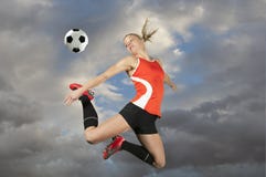 Jogador de futebol fêmea que retrocede uma esfera fotografia de stock royalty free Jogador de futebol fêmea que retrocede uma esfera fotografia de stock royalty free