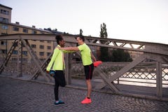 Jogging пары нагревая и протягивая в городе Стоковая Фотография RF Jogging пары нагревая и протягивая в городе Стоковая Фотография RF