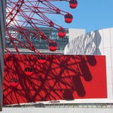 Jogo da sombra, da luz e da cor entre a roda de ferris e os prédios de escritórios foto de stock Jogo da sombra, da luz e da cor entre a roda de ferris e os prédios de escritórios foto de stock