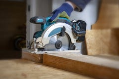 The joiner cuts a wooden board with an electric saw stock image The joiner cuts a wooden board with an electric saw stock image
