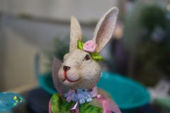 Joli lapin de fille tout orné pour le ressort avec des fleurs et des rubans sur le fond de bokeh image libre de droits Joli lapin de fille tout orné pour le ressort avec des fleurs et des rubans sur le fond de bokeh image libre de droits