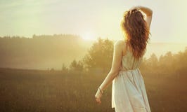 Jolie femme de brune observant le coucher du soleil Photos stock Jolie femme de brune observant le coucher du soleil Photos stock