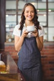 Jolie serveuse offrant une tasse de café photo libre de droits Jolie serveuse offrant une tasse de café photo libre de droits