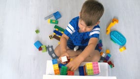 Jong geitje het spelen met logisch stuk speelgoed op vloer in kinderenruimte stock video Jong geitje het spelen met logisch stuk speelgoed op vloer in kinderenruimte stock video