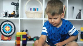 Jong geitje speelstuk speelgoed blokken in witte ruimte stock footage Jong geitje speelstuk speelgoed blokken in witte ruimte stock footage
