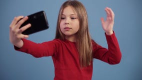 Jong Kaukasisch mooi meisje met lang haar die cheerfuly selfies op de telefoon nemen, die gezichten maken Het kijken op stock video Jong Kaukasisch mooi meisje met lang haar die cheerfuly selfies op de telefoon nemen, die gezichten maken Het kijken op stock video
