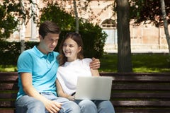 Jong knap paar die notitieboekje in het openbare park gebruiken stock foto's Jong knap paar die notitieboekje in het openbare park gebruiken stock foto's