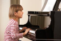 Jong meisje dat grote piano speelt Royalty-vrije Stock Fotografie Jong meisje dat grote piano speelt Royalty-vrije Stock Fotografie