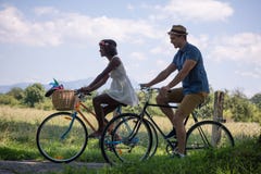 Jong multi-etnisch paar die een fietsrit in aard hebben royalty-vrije stock foto's Jong multi-etnisch paar die een fietsrit in aard hebben royalty-vrije stock foto's