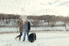 Jong paar die met een hond in een de winterdag lopen Royalty-vrije Stock Foto's Jong paar die met een hond in een de winterdag lopen Royalty-vrije Stock Foto's