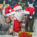 Jong paar die met Kerstman Nieuwjaar 2017, Kerstmis vieren Stock Foto's Jong paar die met Kerstman Nieuwjaar 2017, Kerstmis vieren Stock Foto's