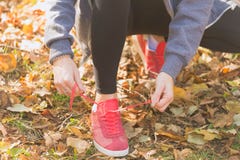 Jong vrouwen bindend kant van loopschoenen vóór de openluchtjogging stock foto Jong vrouwen bindend kant van loopschoenen vóór de openluchtjogging stock foto