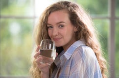 Jong vrouwen drinkwater thuis stock afbeelding Jong vrouwen drinkwater thuis stock afbeelding
