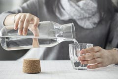 Jong vrouwen gietend water van fles aan glas royalty-vrije stock afbeelding Jong vrouwen gietend water van fles aan glas royalty-vrije stock afbeelding