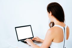 Jonge aantrekkelijke Kaukasische bedrijfsvrouw die en op laptop op bureau - met lege exemplaarruimte werken typen op het monitors stock foto Jonge aantrekkelijke Kaukasische bedrijfsvrouw die en op laptop op bureau - met lege exemplaarruimte werken typen op het monitors stock foto